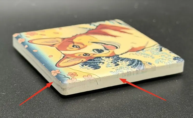 Ink overspray on magnet edge — the dark ink leaked past the magnet surface due to slight alignment drift